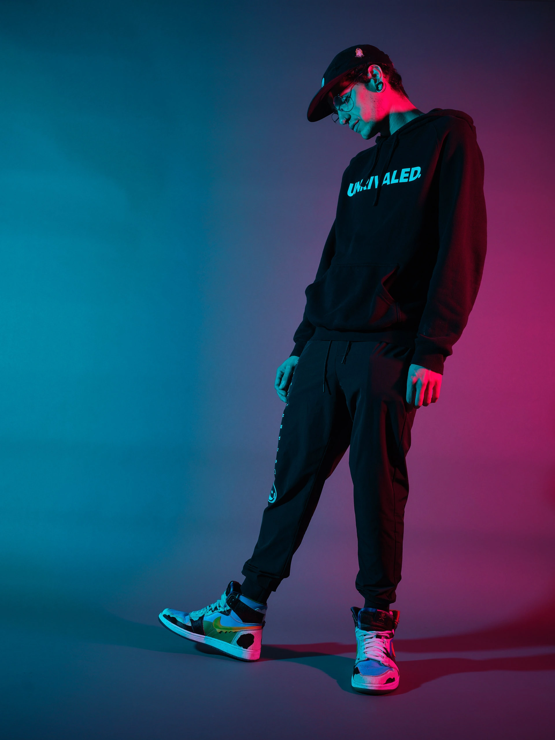 High-contrast technical portrait by San Francisco photographer; featuring a man in streetwear lit with a cyan gelled octabox key and a magenta gelled strip box rim light, captured on GFX for saturated color depth.
